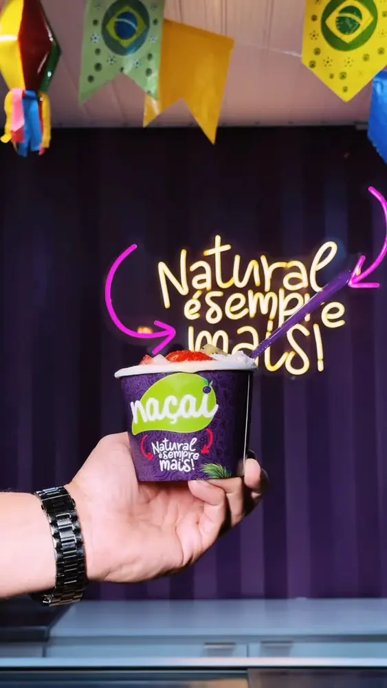 Copo de açaí na frente do neon Natural é sempre mais