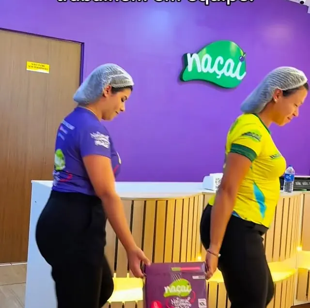 Equipe do Naçaí de touca carregando caixas de açaí